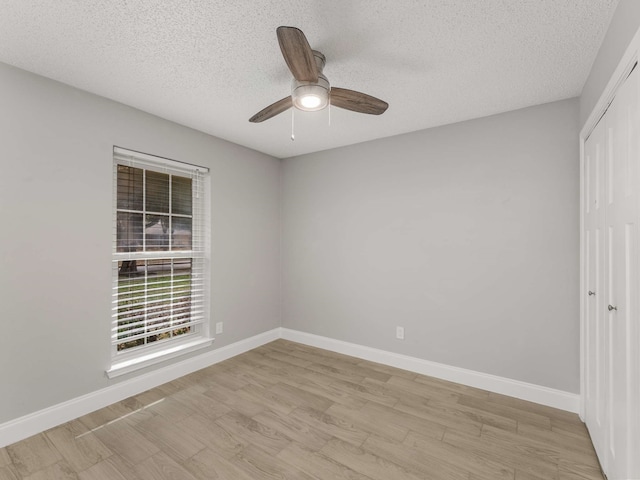 empty room featuring ceiling fan, light hardwood / wood-style flooring, and a textured ceiling