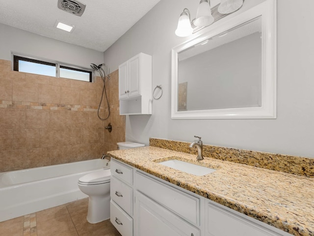 full bathroom featuring toilet, tiled shower / bath, a textured ceiling, vanity, and tile patterned flooring