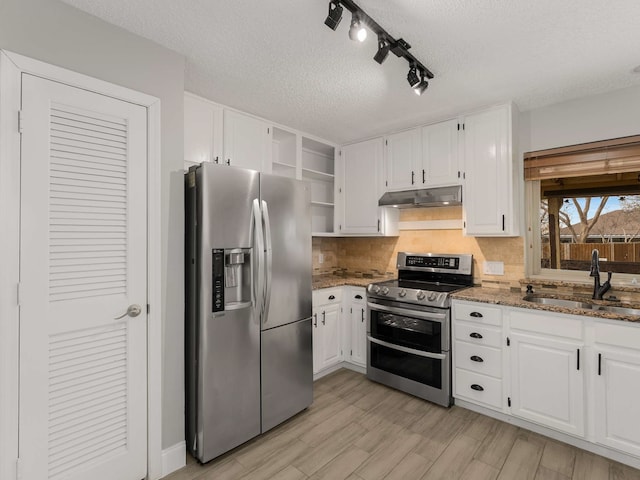 kitchen with appliances with stainless steel finishes, sink, white cabinets, decorative backsplash, and dark stone counters