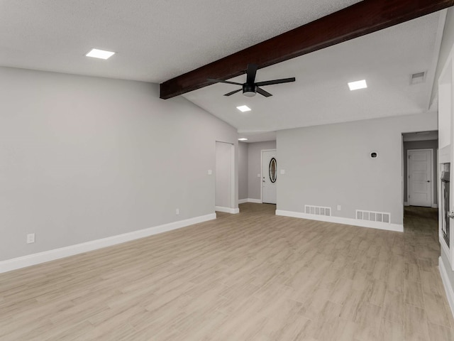 unfurnished living room featuring ceiling fan, lofted ceiling with beams, a textured ceiling, and light wood-type flooring