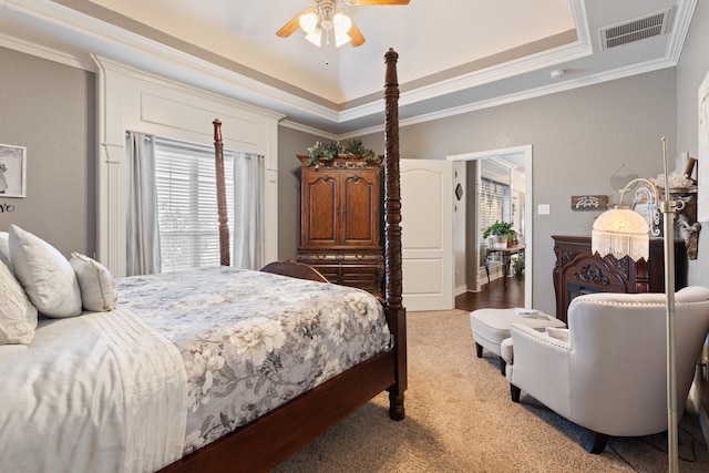 carpeted bedroom featuring crown molding, ceiling fan, and a tray ceiling