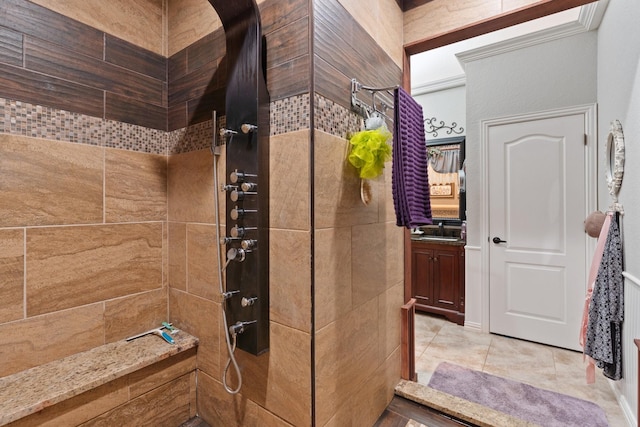 bathroom with tile patterned flooring, sink, and tiled shower