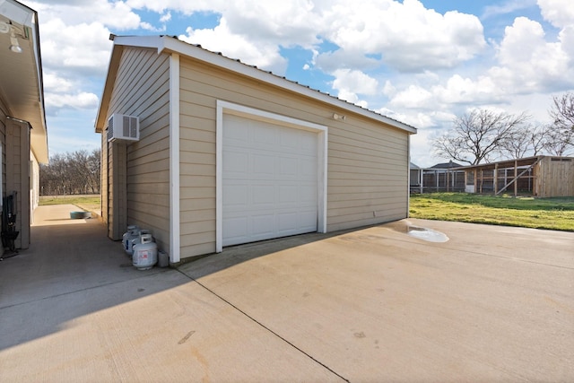 garage featuring a wall unit AC and a lawn