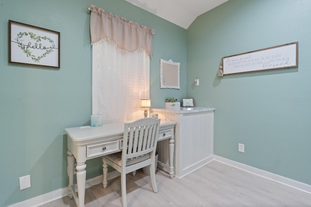 office area with vaulted ceiling and light hardwood / wood-style flooring