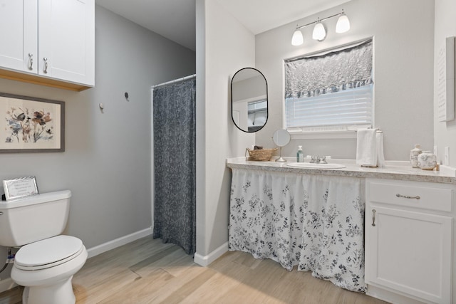 bathroom with hardwood / wood-style flooring, vanity, toilet, and a shower with shower curtain