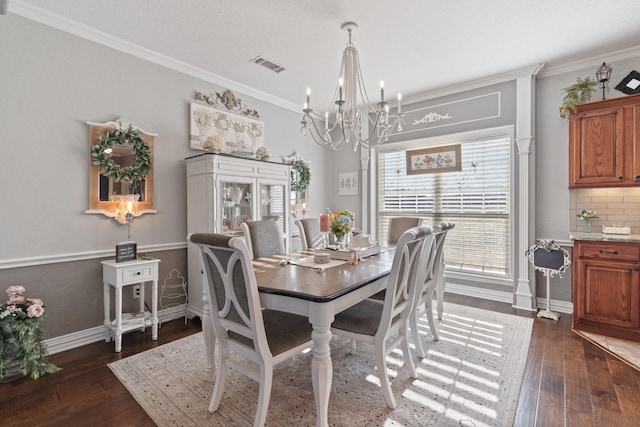 dining space featuring dark wood-type flooring, ornamental molding, and a chandelier