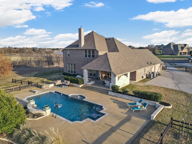 outdoor pool featuring fence private yard, a hot tub, central AC, and a patio