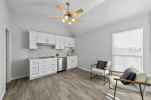 kitchen with black electric stovetop, tasteful backsplash, a sink, dishwasher, and under cabinet range hood