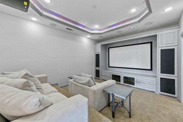 home theater room with visible vents, a raised ceiling, light colored carpet, ornamental molding, and recessed lighting