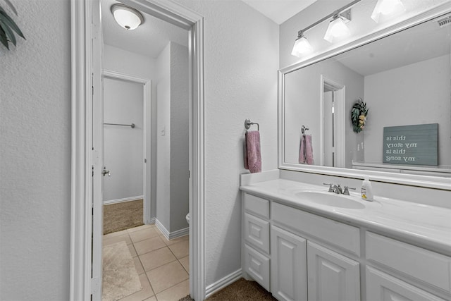 bathroom with tile patterned flooring, toilet, visible vents, vanity, and baseboards