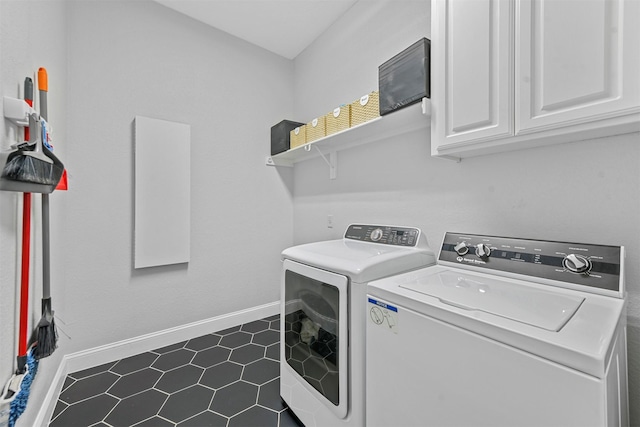 clothes washing area with baseboards, cabinet space, and washer and dryer