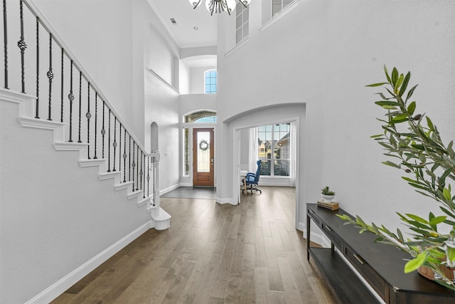 foyer entrance featuring a healthy amount of sunlight, stairs, baseboards, and wood finished floors