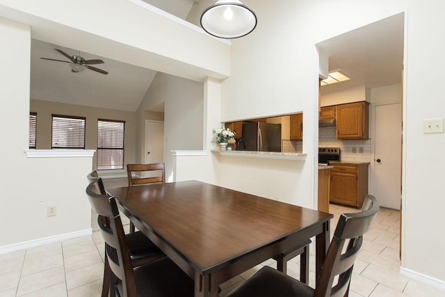 tiled dining area with vaulted ceiling and ceiling fan