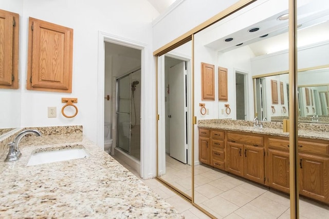 bathroom featuring tile patterned flooring, vanity, and walk in shower