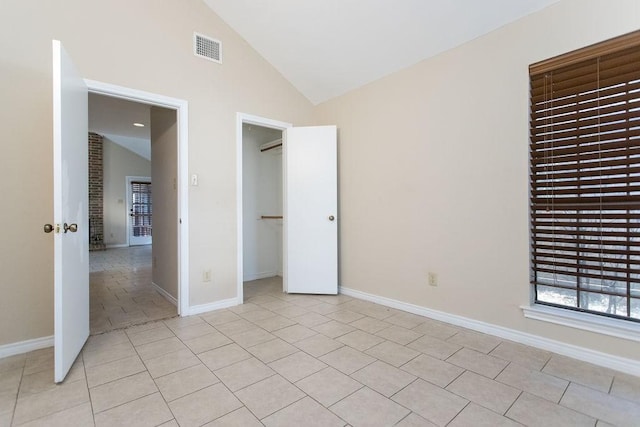 unfurnished bedroom featuring light tile patterned floors, high vaulted ceiling, and a closet