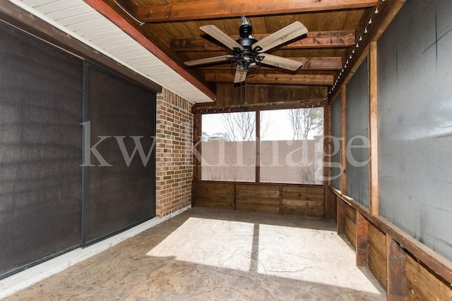 unfurnished sunroom featuring ceiling fan and beamed ceiling