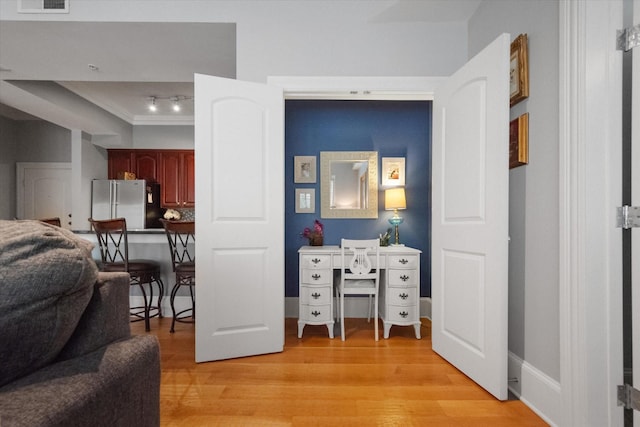 bedroom featuring light hardwood / wood-style flooring, high quality fridge, and rail lighting