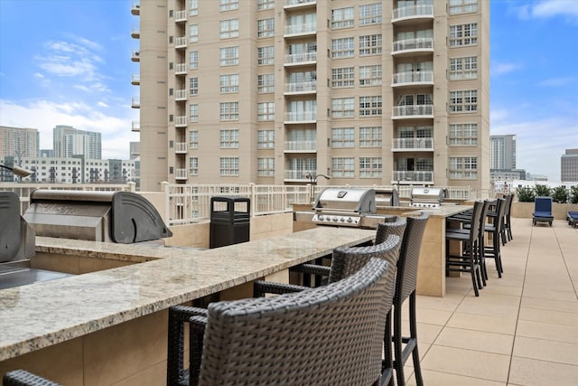 view of patio with exterior kitchen, exterior bar, and area for grilling