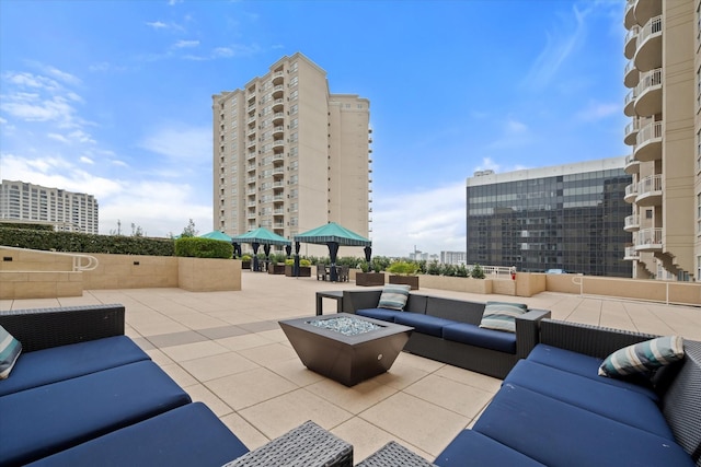 view of patio featuring a gazebo and an outdoor living space with a fire pit