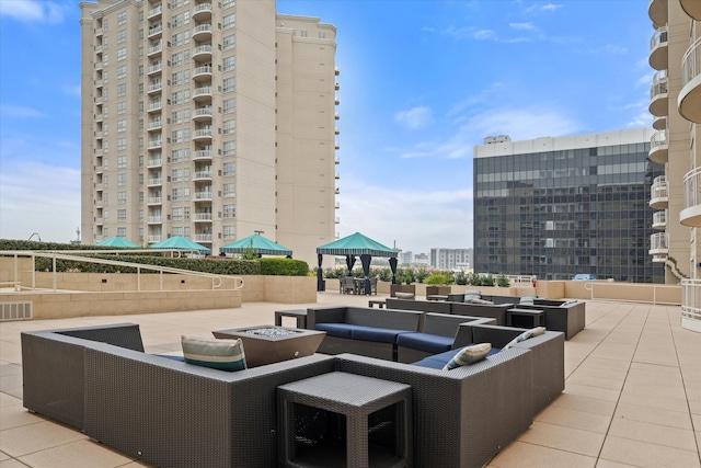 view of patio featuring a gazebo and an outdoor living space with a fire pit