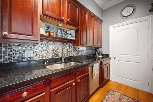 kitchen with sink, crown molding, dishwasher, dark stone countertops, and light wood-type flooring