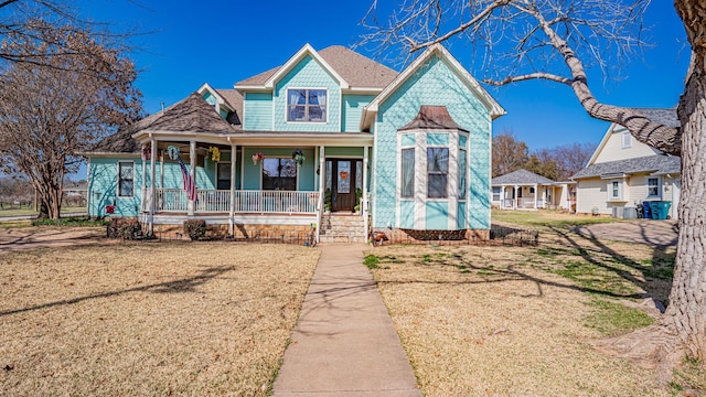 view of front of home with a front yard and covered porch