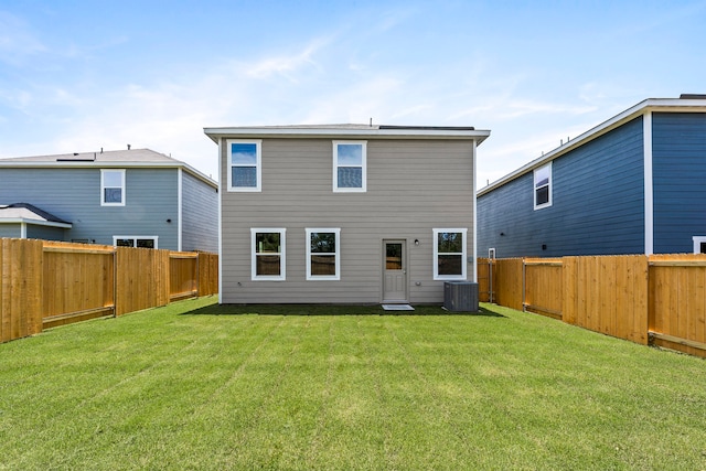 rear view of house featuring central AC and a yard