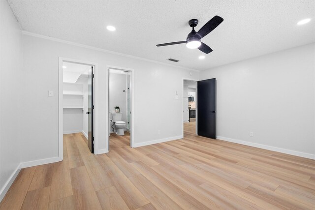 spare room featuring ceiling fan, light hardwood / wood-style flooring, and a textured ceiling