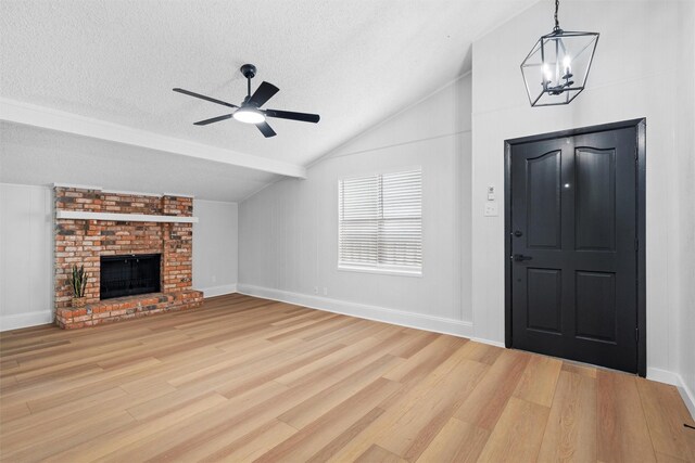 unfurnished living room with french doors, wood-type flooring, vaulted ceiling, a brick fireplace, and a textured ceiling