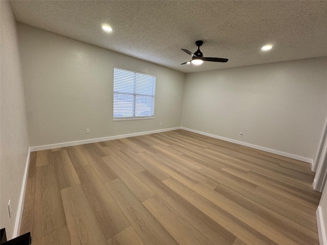 spare room featuring a textured ceiling, light hardwood / wood-style flooring, and ceiling fan