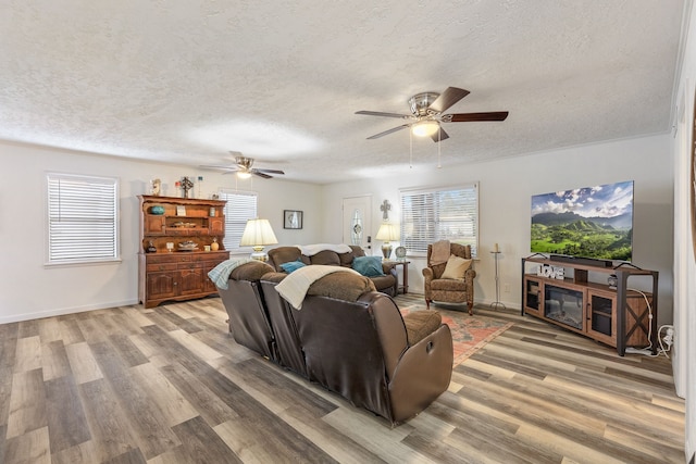 living room with wood-type flooring, a healthy amount of sunlight, and ceiling fan