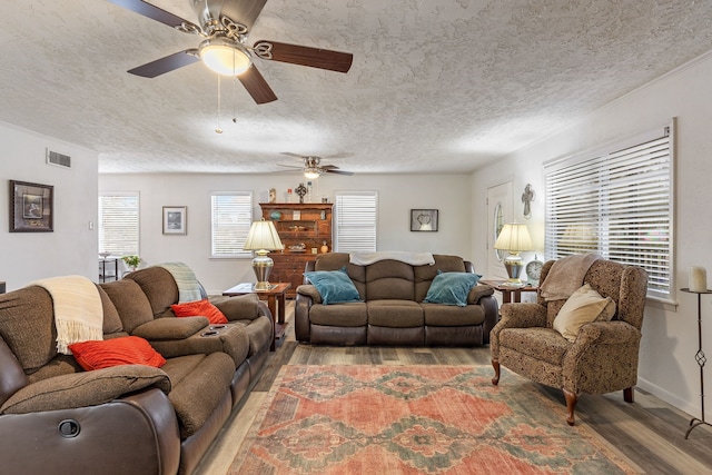 living room featuring ceiling fan, hardwood / wood-style floors, and a textured ceiling