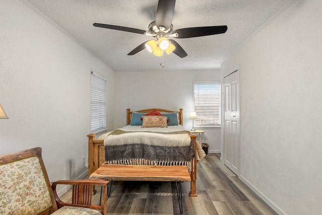 bedroom with wood-type flooring, ceiling fan, a textured ceiling, and crown molding