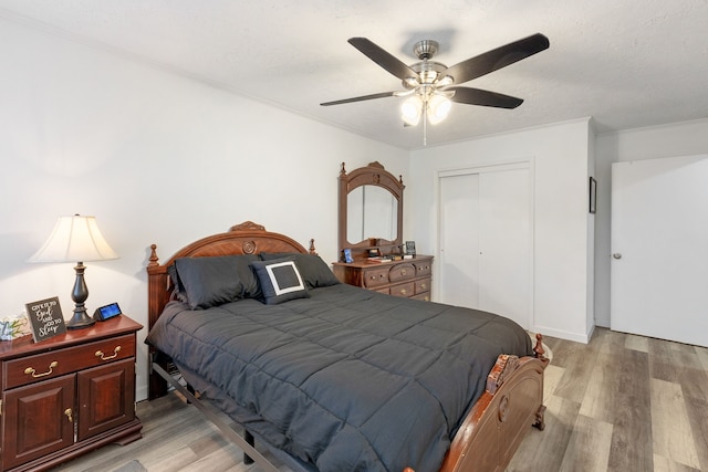 bedroom featuring ceiling fan, light wood-type flooring, and a closet