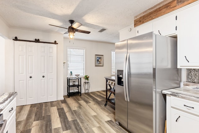 kitchen featuring white cabinetry, stainless steel fridge, dark hardwood / wood-style flooring, and a textured ceiling