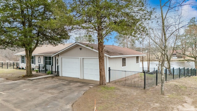 view of front of property with a garage and a water view