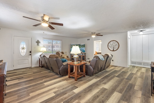 living room with ceiling fan, dark hardwood / wood-style floors, and a textured ceiling