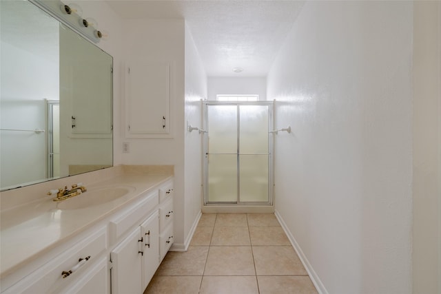 bathroom with tile patterned flooring, vanity, an enclosed shower, and a textured ceiling