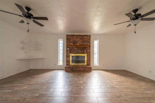 unfurnished living room with ornamental molding, plenty of natural light, a textured ceiling, and a fireplace