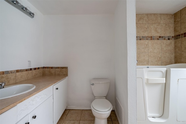 bathroom featuring vanity, tile patterned floors, and toilet