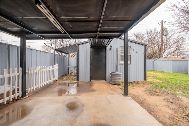 view of patio featuring central AC unit and a storage shed