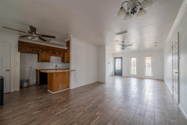 unfurnished living room with hardwood / wood-style flooring, ornamental molding, sink, and ceiling fan with notable chandelier