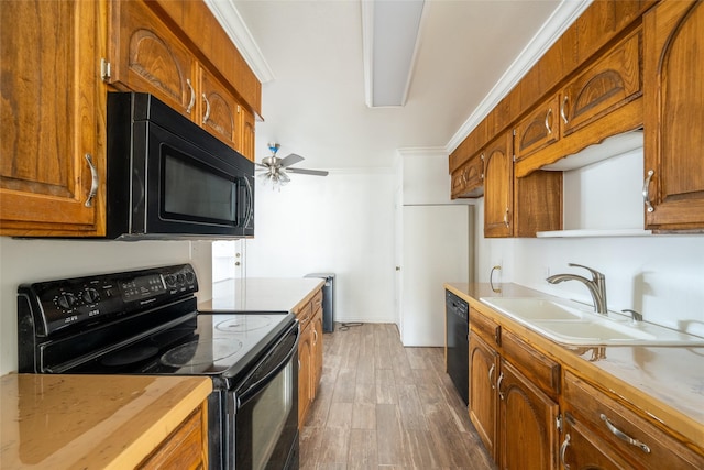 kitchen with crown molding, sink, dark hardwood / wood-style floors, and black appliances