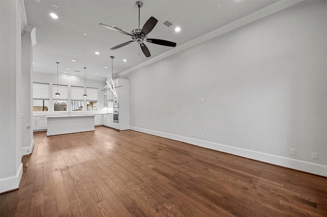 unfurnished living room with hardwood / wood-style flooring, crown molding, and ceiling fan