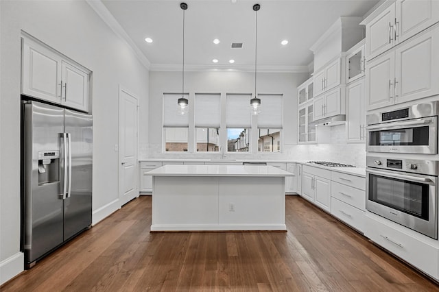 kitchen with white cabinetry, stainless steel appliances, and a kitchen island