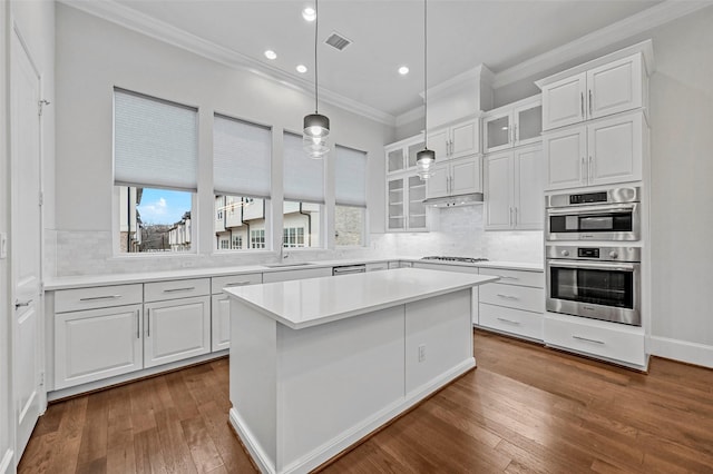 kitchen featuring sink, a kitchen island, a wealth of natural light, stainless steel appliances, and white cabinets