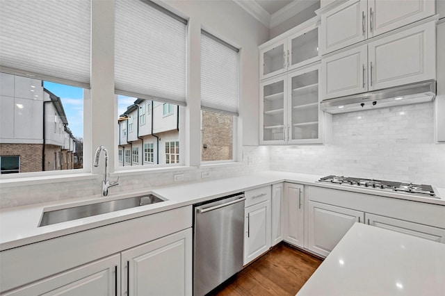 kitchen with sink, tasteful backsplash, crown molding, appliances with stainless steel finishes, and white cabinets