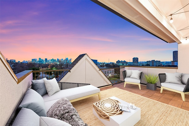 patio terrace at dusk with a balcony and an outdoor hangout area