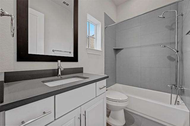 full bathroom featuring vanity, tiled shower / bath combo, and toilet