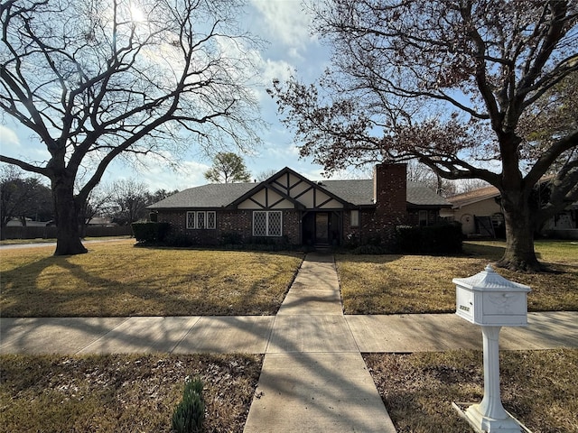 tudor-style house featuring a front lawn